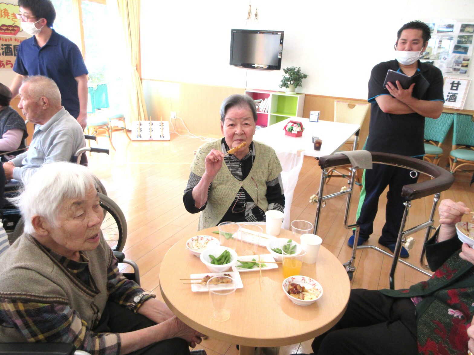 介護施設での食事レクリエーション。入居者と職員が一緒に食事をしながら交流している様子。